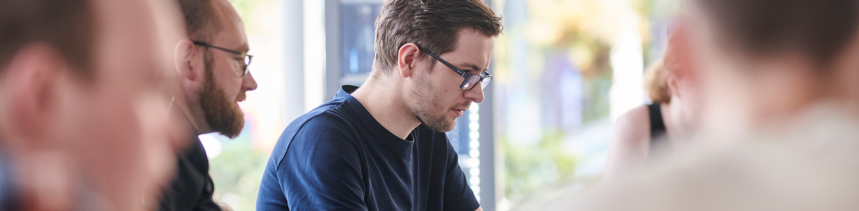Projektteam in der Softwareentwicklung eines Maklerunternehmens mit KI-Unterstützung