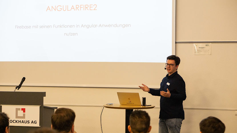 Tim Kwiatkowski steht vor dem Publikum und referiert über das Thema AngularFire2