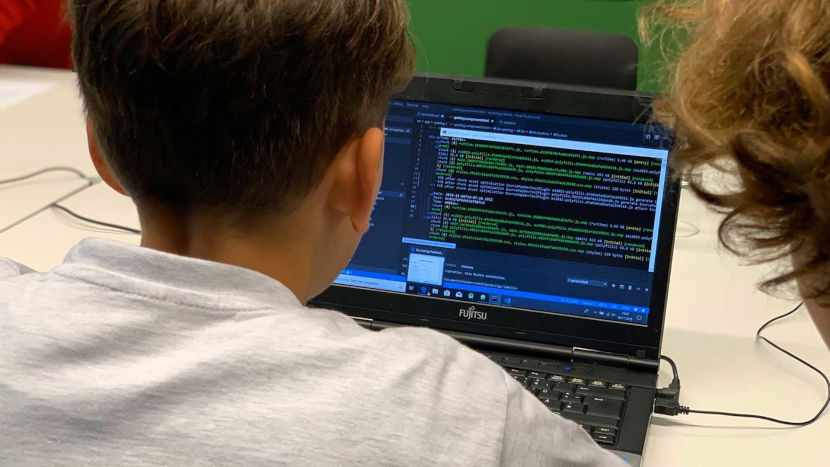 Das Foto zeigt zwei Kinder beim programmieren am Laptop